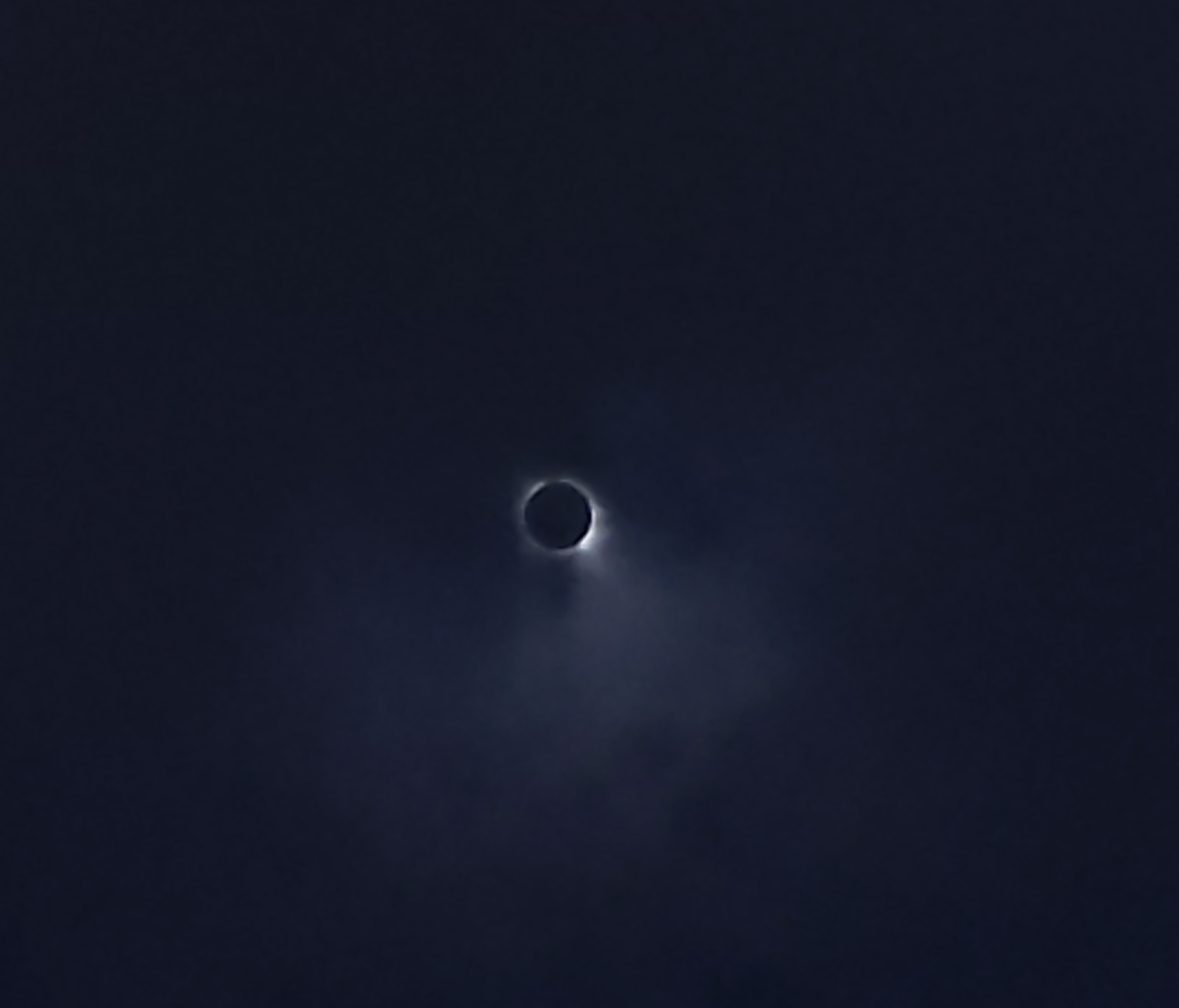 A total solar eclipse seen through clouds